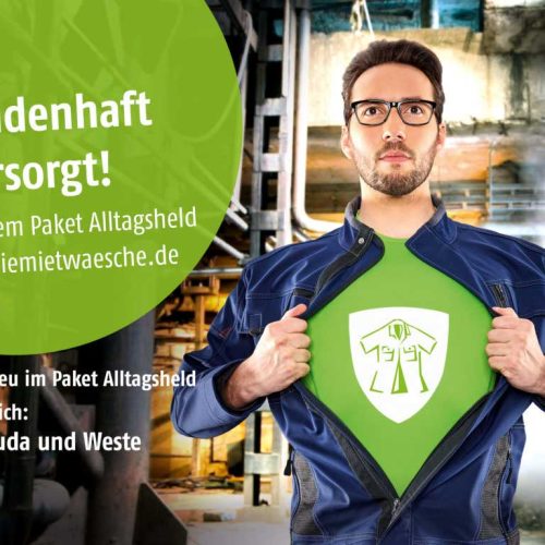 Mann mit Brille, trägt blauen Arbeits-Overall, darunter ein grünes Shirt mit dem diemietwäsche-Logo; Text: Heldenhaft versorgt! Mit dem Paket Alltagsheld von diemietwaesche.de; Jetzt neu im Paket Alltagsheld erhältlich: Bermuda und Weste