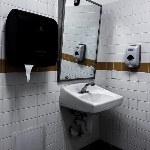 Restaurant-Toiletten-Waschbecken mit Spiegel, Seifenspender und Stoffhandtuchspender