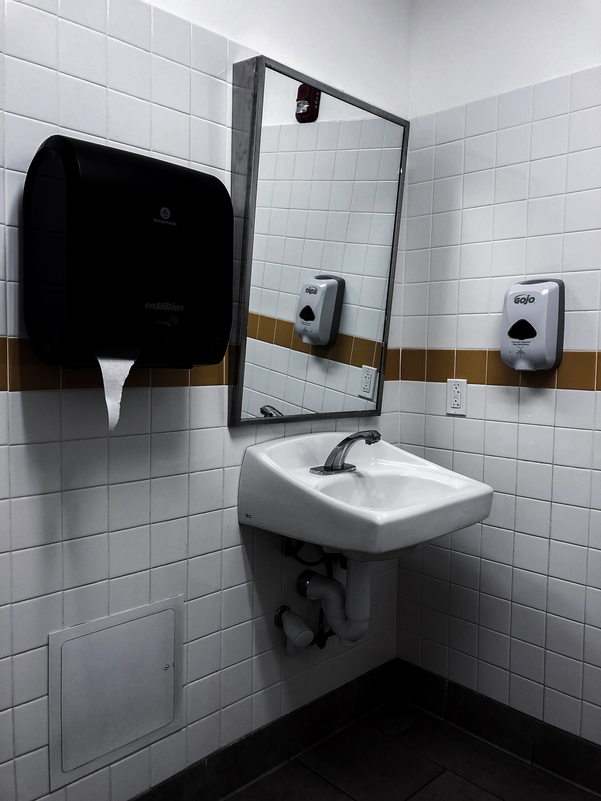 Restaurant-Toiletten-Waschbecken mit Spiegel, Seifenspender und Stoffhandtuchspender