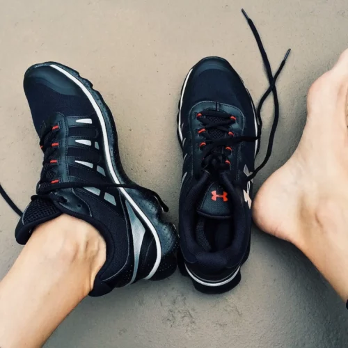 linker Fuß im Sportschuh, rechter Fuß außerhalb