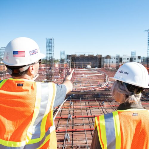 Hausbau, Arbeiter und Arbeiterin auf Baustelle