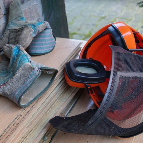 Schutzhandschuhe, Schutzhelm, Hörschutz auf Tisch