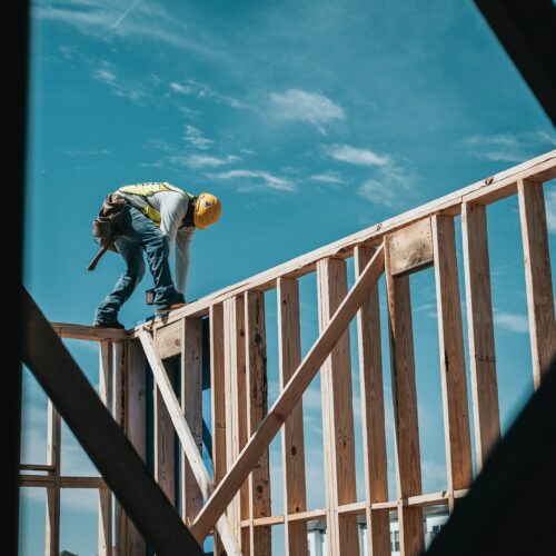 Arbeiter auf Holzgerüst eines Hauses