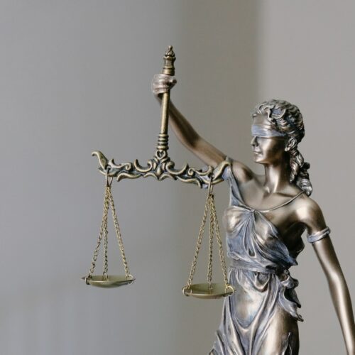 Statue der Justizia, die Waage in der rechten und das Schwert in der linken Hand hält