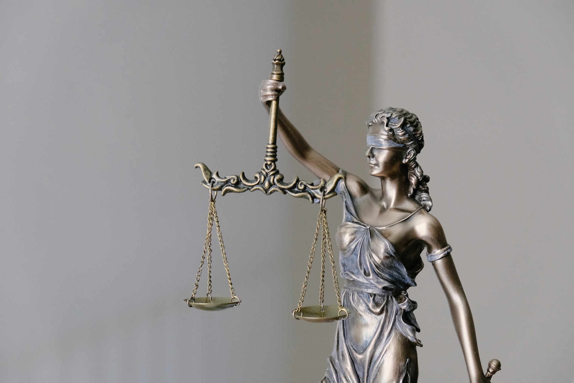 Statue der Justizia, die Waage in der rechten und das Schwert in der linken Hand hält